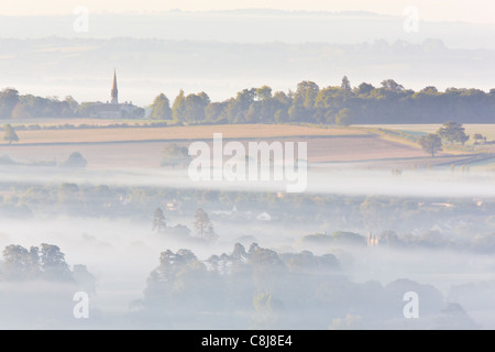 Vista di Glastonbury dal vertice di Glastonbury Tor in una nebbiosa mattina appena dopo l'alba Foto Stock