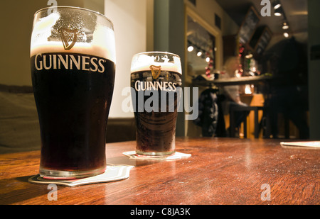 Pinte di birra Guinness alla tabella in un pub inglese Foto Stock