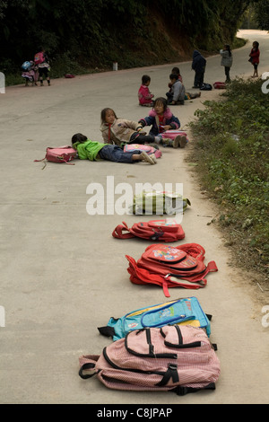 Andare a scuola in campagna cinese, in attesa di un autobus dopo la scuola, etnica, gruppo, minoranza, Miao, persone Foto Stock