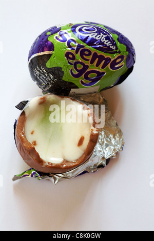 Due Cadburys screme uova, screme uovo, mostrando una addentata con verde medio soprattutto per la festa di Halloween isolati su sfondo bianco Foto Stock