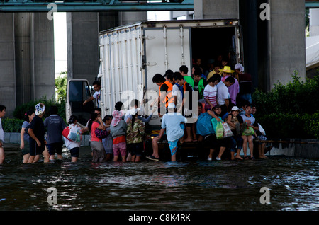 Thai i rifugiati ottenere sul carrello di overload durante l'alluvione,'aeroporto Don Muang di Bangkok, Tailandia. Credito: Kraig Lieb Foto Stock