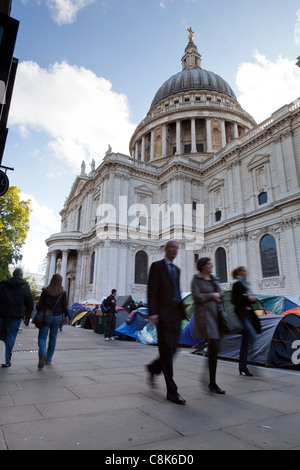 I passanti a piedi passato l'anti-capitalista manifestanti' accampamento al di fuori dalla cattedrale di St Paul, Londra, ottobre 2011. Foto Stock