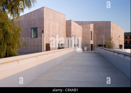 Vista lungo il ponte pedonale fino al museo d'arte e scultura della Hepworth Gallery (esterno in cemento illuminato dal sole sotto il cielo blu) - Wakefield, West Yorkshire, Inghilterra, Regno Unito. Foto Stock