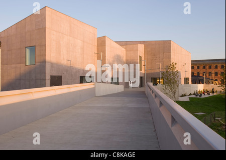 Vista lungo il ponte pedonale fino al museo d'arte e scultura della Hepworth Gallery (esterno in cemento illuminato dal sole sotto il cielo blu) - Wakefield, West Yorkshire, Inghilterra, Regno Unito. Foto Stock