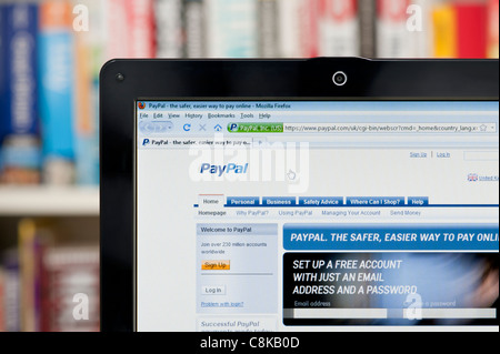 Il sito web di PayPal sparato contro una libreria sullo sfondo (solo uso editoriale: -print, TV, e-book e Redazione sito web). Foto Stock
