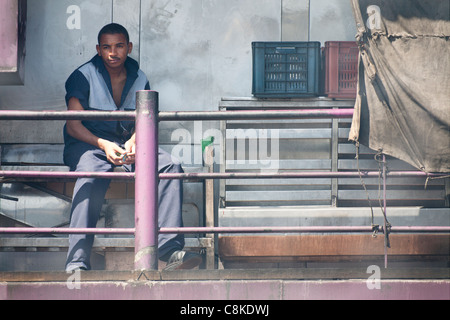 Un membro dell'equipaggio di crociera sul Nilo barca in seduta il fumoso fumi a poppa della nave Foto Stock