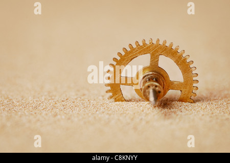 Orologio - dettaglio un ingranaggio nella sabbia vicino fino Foto Stock