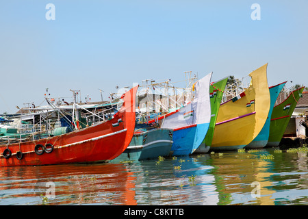 Orizzontale indiano colorate barche da pesca imbarcazioni ormeggiate sulle banche di Kochin Backwaters nel Kerala cielo azzurro acqua riflessioni Foto Stock