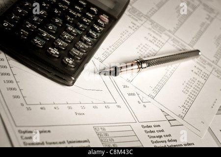 Financial di grafici e tabelle che giace sul tavolo con la calcolatrice e penna Foto Stock