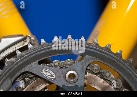 La parte anteriore chainwheels (denti) e la catena su di un deragliatore di bicicletta la serie di ingranaggi. Foto Stock