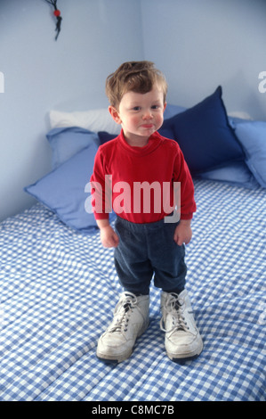 Ragazzo che indossa i suoi padri scarpe Foto Stock