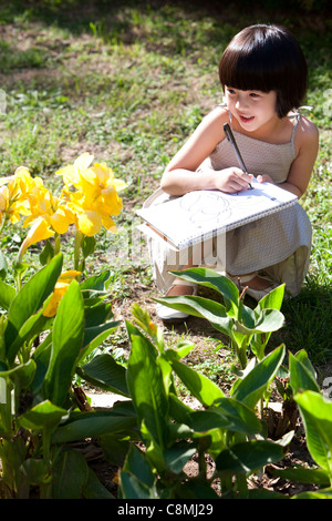 Bambina pittura in giardino Foto Stock