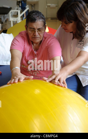 Fisioterapista femminile aiutando un paziente di fare un esercizio Foto Stock