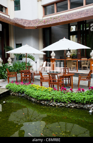 Patio con giardino con sedie sdraio e ombrelloni da the waterside Foto Stock