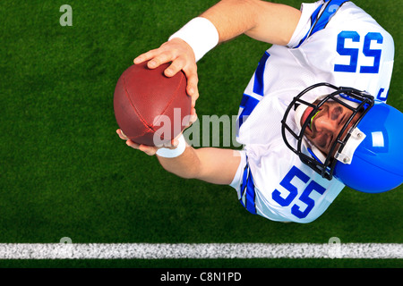Foto aerea di un giocatore di football americano wide receiver cattura la palla in aria. Foto Stock