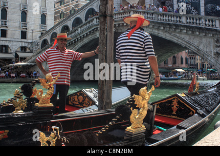 Gondolieri a Venezia, Italia. Due gondolieri nella parte anteriore del ponte di Rialto. Foto Stock