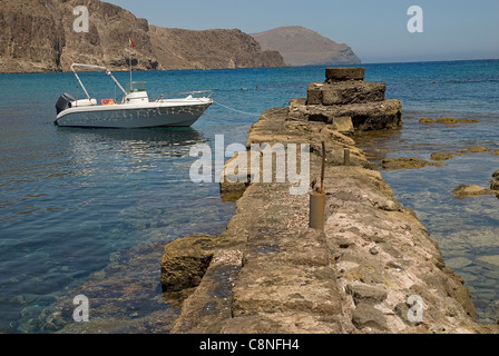 Spagna, Andalusia Almeria, La Isleta del Moro, vecchio molo di pietra con la barca ormeggiata su un lato Foto Stock