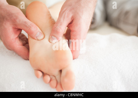 L'uomo massaggiare una donna di piedi Foto Stock
