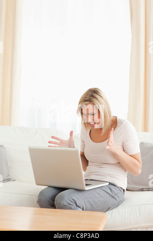 Il Portrait di sconvolgere un donna bionda con un laptop Foto Stock