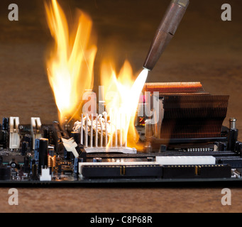 Sbatti fiamme da una saldatura rorch durante la masterizzazione di una scheda principale che si trova in atmosfera arrugginito Foto Stock