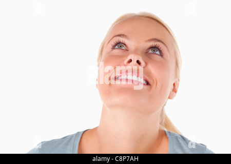 Sorridente donna bionda guardando il soffitto Foto Stock