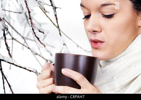 Bella giovane donna di bere bevande calde in inverno freddo giorno Foto Stock