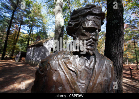 Una statua di Henry David Thoreau davanti a una replica della sua cabina a Walden Pond, Concord, Massachusetts Foto Stock