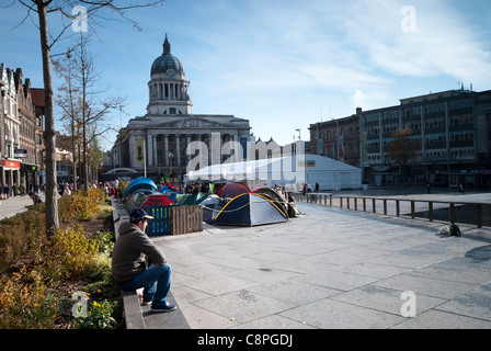 L'uomo guarda al di fuori dei manifestanti camp di occupare il movimento nella piazza del mercato di Nottingham, Inghilterra, Regno Unito. Foto Stock