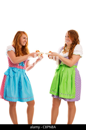 Due bavarese ragazze vestito tirando su salsicce di vitello su sfondo bianco Foto Stock