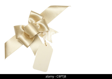 Golden ribbon bow con blank gift tag.isolato su bianco. Foto Stock