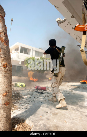 Rebel fighter battaglie cecchini nella piazza occupata dalle forze di Gheddafi sul finale il giorno della liberazione di Zarwiya Foto Stock