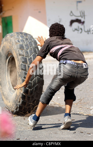 Rebel fighter battaglie cecchini nella piazza occupata dalle forze di Gheddafi sul finale il giorno della liberazione di Zarwiya Foto Stock