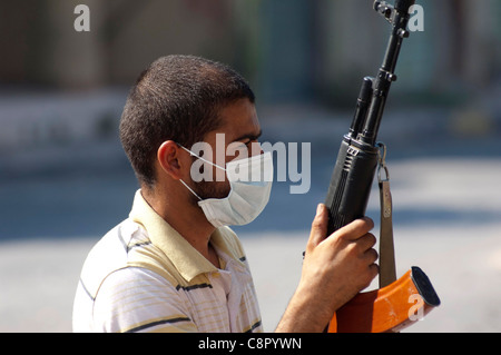 Rebel fighter battaglie cecchini nella piazza occupata dalle forze di Gheddafi sul finale il giorno della liberazione di Zarwiya Foto Stock