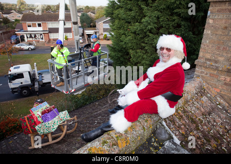 Santa Claus fornisce il suo roof top magic con l aiuto di un cherry picker REGNO UNITO Foto Stock