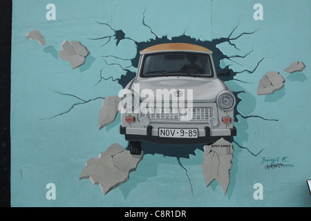 Trabant rottura attraverso la parete raffigurata sul muro di Berlino in East Side Gallery di Berlino, Germania. Foto Stock