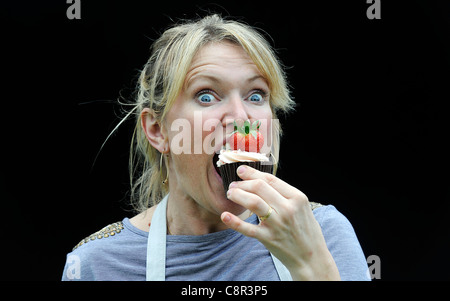 Celebrity Chef e il libro di ricette autore Rachel Allen foto di mangiare una tortina contro uno sfondo nero. Foto Stock