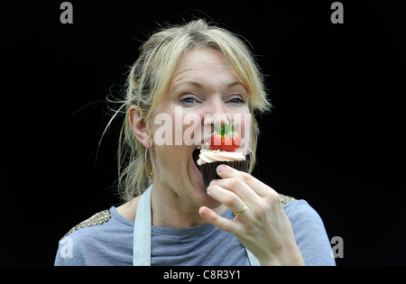 Celebrity Chef e il libro di ricette autore Rachel Allen foto di mangiare una tortina contro uno sfondo nero. Foto Stock