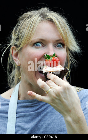 Celebrity Chef e il libro di ricette autore Rachel Allen foto di mangiare una tortina contro uno sfondo nero. Foto Stock