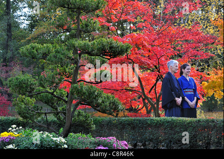 Uomo e donna che indossa kimono in giardino Giapponese con chioma in rosso i colori autunnali nella città di Hasselt, Belgio Foto Stock