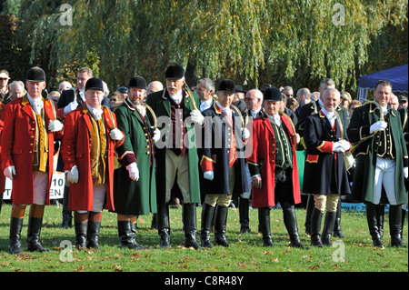 Cacciatori con corni da caccia che indossa il rosso e il verde cappotti durante Saint Hubert / Saint Hubertus commemorazione in autunno, Belgio Foto Stock