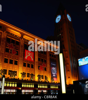 La torre dell orologio e il centro commerciale sulla via Wangfujing di Pechino di notte Repubblica Popolare Cinese Foto Stock