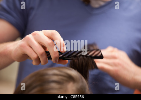 Mano pettinare capelli Foto Stock