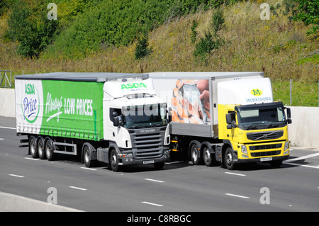 Supermercato Asda consegna camion e rimorchio il sorpasso di un analogo Morrisons autocarro sia la visualizzazione di grafica pubblicitaria Foto Stock