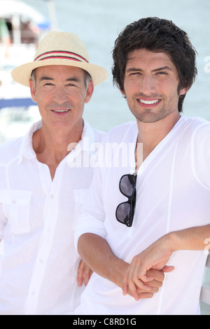 Padre e figlio cresciuto godendo il sole Foto Stock