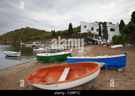 Barche sulla spiaggia di fronte a Salvador Dali Casa-museo in Portlligat. Cadaques, Catalogna, Spagna. Foto Stock