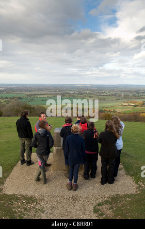 Gruppo di persone intorno a un topografo toposcope o su Coombe collina con vista su Aylesbury Vale Buckinghamshire campagna Foto Stock