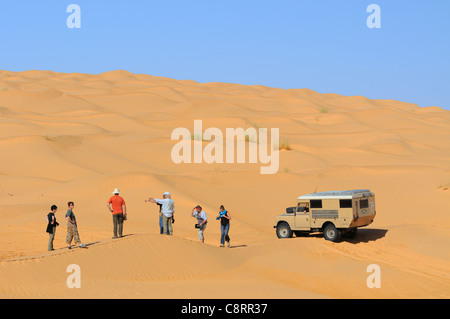 Africa, Tunisia, nr. Tembaine. Viaggiatori nel deserto con uno dei loro veicoli, un ex-army 1966 Land Rover Serie 2a camper van ... Foto Stock