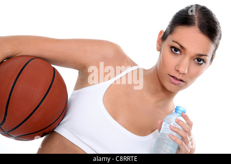 Donna con una palla da basket e una bottiglia di acqua Foto Stock