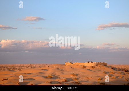 Africa, Tunisia, Ksar Rhilane. Turisti che si godono il tramonto i resti della vecchia storica fortezza romana Ksar Ghilane ... Foto Stock