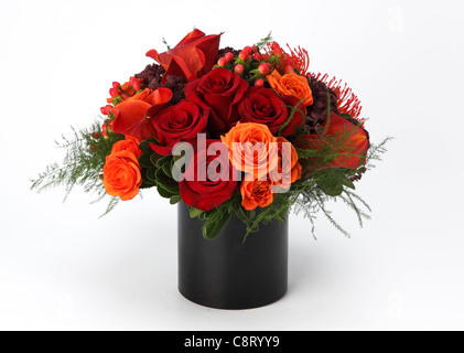 Un colorato bouquet di fiori in un vaso. Red & Rose arancione, rosso callas, rosso proteas, sconosciuto spruzzi di colore viola Foto Stock